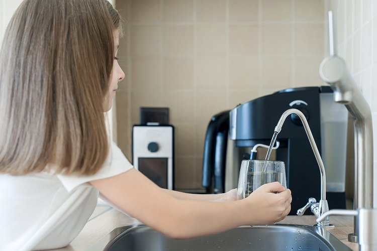 Dziecko wlewa wodę z kranu do szklanki – Uzdatnianie wody